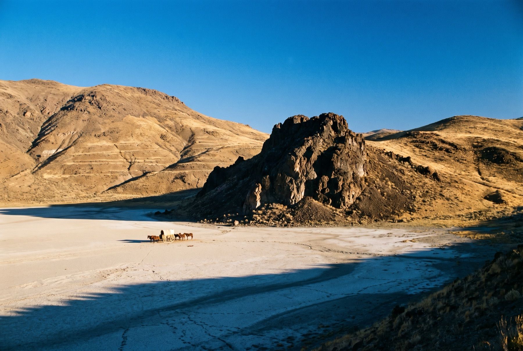 The dark volcanic formation of Black Rock Point standing starkly above the level desert playa.