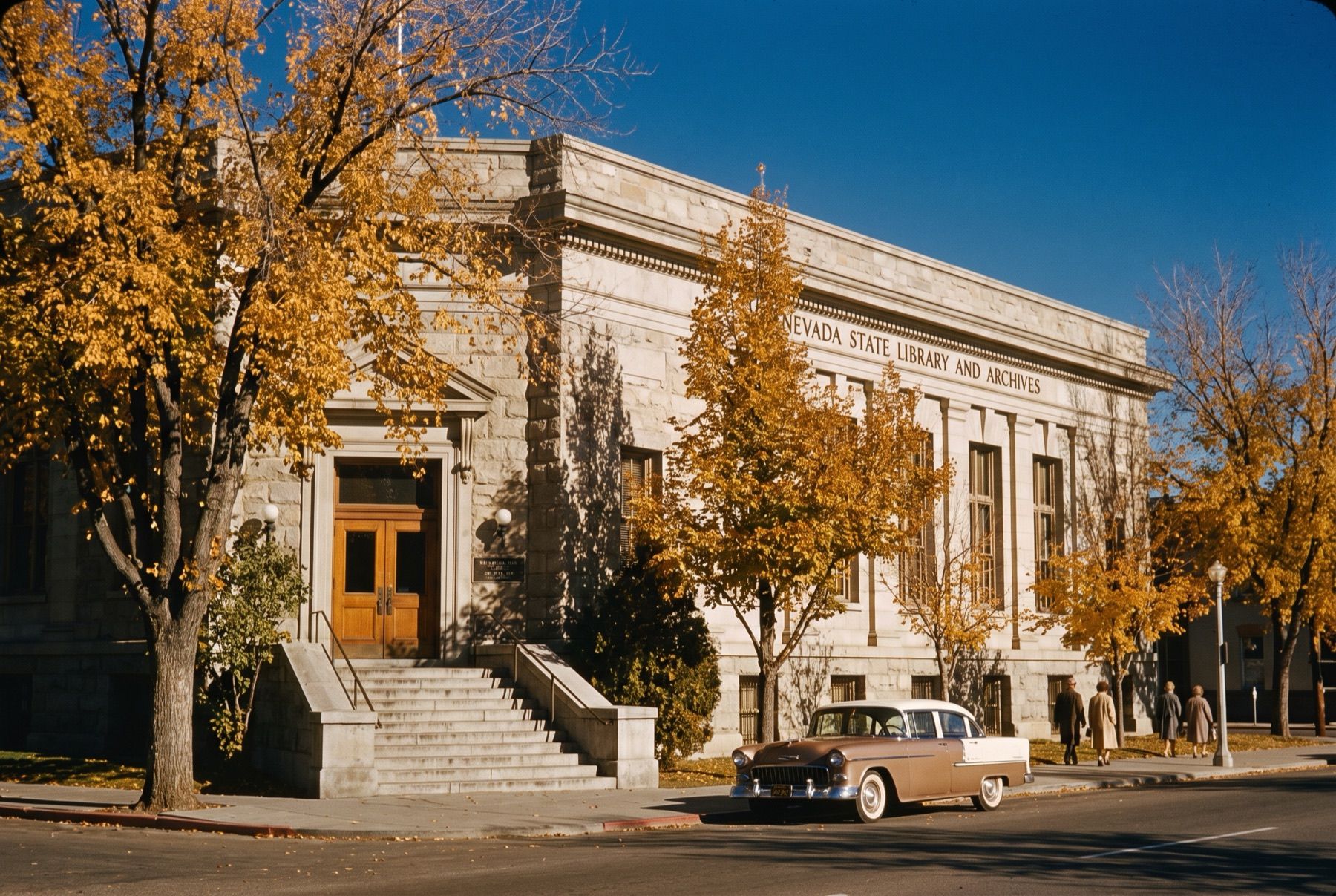 Exterior of the Nevada State Library and Archives building in Carson City with autumn trees.