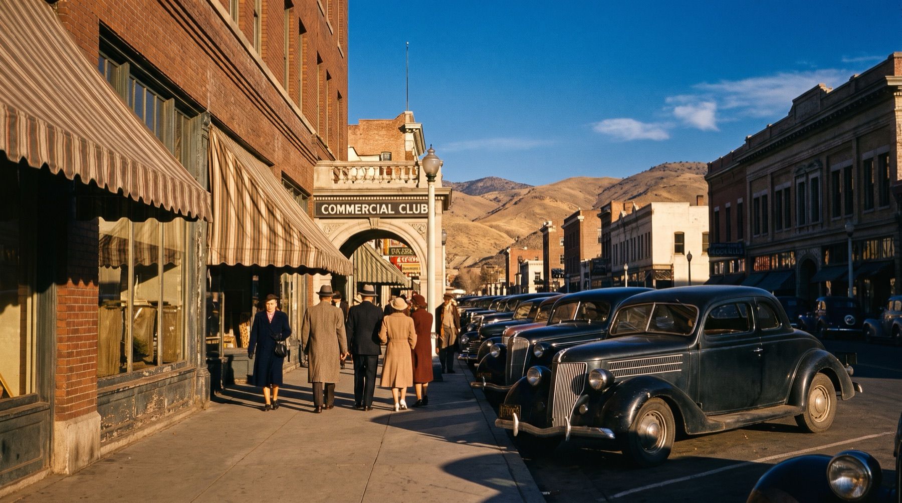 Downtown Reno street scene in the late 1930s showing vintage automobiles parked along storefronts.